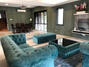 - un salon avec deux canapés bleus et une table dans l'établissement Orak Villa @ Kayangan Heights, à Shah Alam