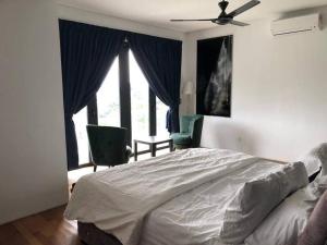 1 dormitorio con 1 cama, 2 sillas y ventana en Orak Villa @ Kayangan Heights, en Shah Alam