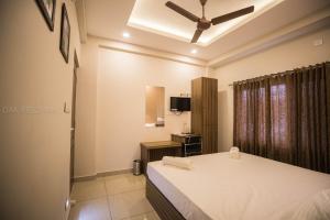 a bedroom with a bed and a ceiling fan at Oak Field Inn in Cochin