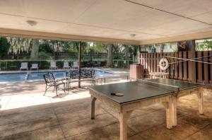 a room with a ping pong table and a swimming pool at Turtle Cove in Saint Simons Island