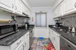 a kitchen with white cabinets and a sink at Ocean Walk B-6 in Mallory Park