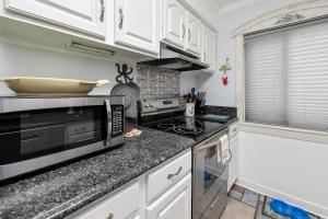 a kitchen with a microwave and a stove top oven at Ocean Walk B-6 in Mallory Park