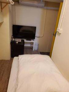 - une chambre avec un lit et une télévision à écran plat dans l'établissement Taipei Inn, à Taipei