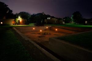 un giardino notturno con luci nel cortile di DE SOL Y BARRO Moche Trujillo a Trujillo