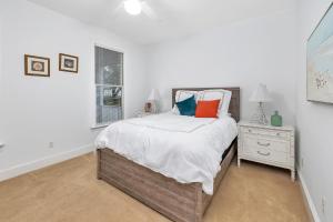ein weißes Schlafzimmer mit einem Bett und einem Fenster in der Unterkunft Carolyns by the Sea in Saint Simons Island