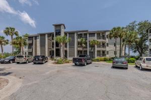 a parking lot with cars parked in front of a building at Birds Eye View in Saint Simons Island