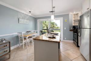 a kitchen with a sink and a refrigerator and a table at Birds Eye View in Saint Simons Island