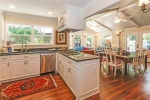 a kitchen with white cabinets and a dining room with a table at 120 Druid Oaks Lane in Saint Simons Island