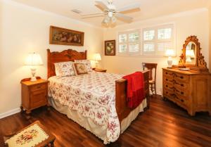 a bedroom with a bed and a ceiling fan at 120 Druid Oaks Lane in Saint Simons Island