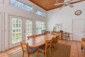 een eetkamer met een houten tafel en stoelen bij Island Breeze in Saint Simons Island