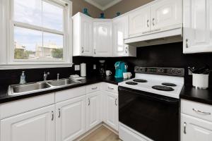 a kitchen with white cabinets and a sink and a stove at 221 Olive Way in Saint Simons Island