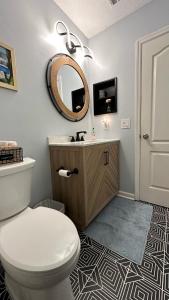 a bathroom with a white toilet and a mirror at The Squeezebox in Saint Simons Island