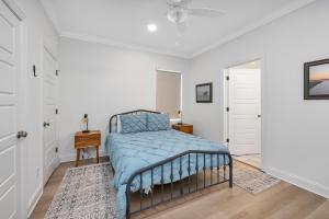 a bedroom with a bed with a blue comforter at Baisden Cottage in Saint Simons Island