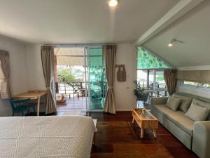 a bedroom with a bed and a couch and a table at Siam Cookies Cottage in Haad Pleayleam +116 photos