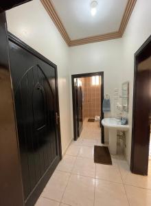Al-Salam的住宿－ستوديو كبير غرفة و حمام بمكيف غسالة تلفاز واي فاي，浴室设有黑色的门和水槽。