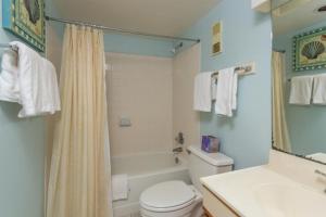 ein Badezimmer mit einem WC, einer Badewanne und einem Waschbecken in der Unterkunft Beach Club 208 in East End