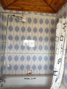 a bathroom with a tub with blue tiles at Zack's Serene House in Kisii
