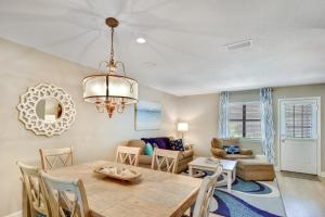 a dining room and living room with a table and chairs at Courtyard Villa C-4 Butterfly Villa in Saint Simons Island