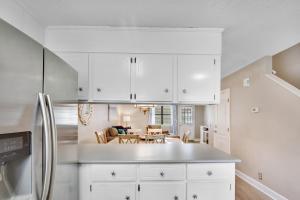 a kitchen with white cabinets and a dining room at Courtyard Villa C-4 Butterfly Villa in Saint Simons Island