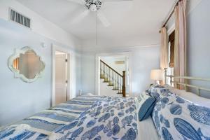 Schlafzimmer mit einem Bett mit einer blauen und weißen Bettdecke in der Unterkunft Meridian Cottage at Coast Cottages in East End