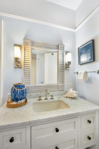 un bagno con lavandino e specchio di Catherine Cottage a East End Altre 24 foto