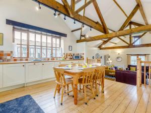 uma cozinha e sala de estar com uma mesa de madeira e cadeiras em 2 Bed in Holsworthy GFOXG em Sutcombe