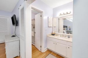 un bagno bianco con lavandino e specchio di Fairway Villa #410 a Saint Simons Island Altre 15 foto