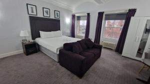 een slaapkamer met een bed, een stoel en ramen bij Carlisle Station Hotel, Sure Hotel Collection by BW in Carlisle