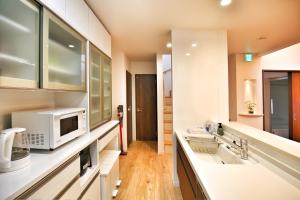 a kitchen with two sinks and a microwave at kameido k hotel in Tokyo