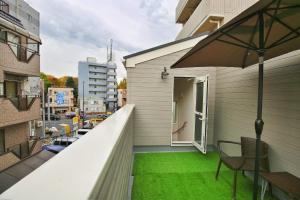 a balcony with green grass and an open door at kameido k hotel in Tokyo
