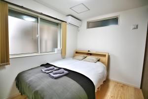 a bedroom with a bed with two towels on it at kameido k hotel in Tokyo