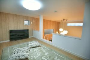 ein Wohnzimmer mit einem Flachbild-TV und einem Bett in der Unterkunft kameido k hotel in Tokio
