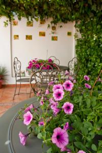 Casa de La Campana في ثيثا: طاولة وكراسي مع زهور وردية على الفناء