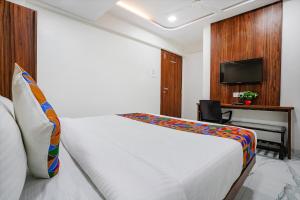 Schlafzimmer mit einem Bett und einem Schreibtisch mit einem TV in der Unterkunft FabHotel New 7 Star in Mumbai