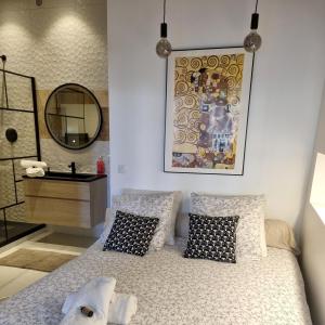 1 dormitorio con cama con espejo y lavamanos en Appartement T2 40m2 Rénové Au Coeur du Panier Vieux Port, en Marsella