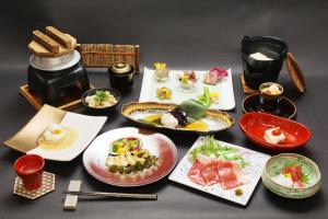 stół z kilkoma talerzami żywności w obiekcie 京ごはんと露天風呂の宿 ゆのはな 月や 