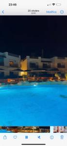 a picture of a large blue swimming pool at night at Domina coral bay elisir SPA in Sharm El Sheikh