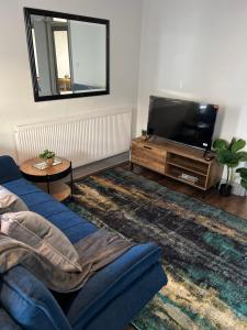 a living room with a blue couch and a tv at Dalston 1 bedroom flat in London