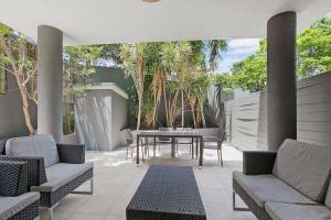 une terrasse avec une table, des chaises et des arbres dans l'établissement 'Attiva' A Brisbane Gem with Pool and Private Patio, à Brisbane