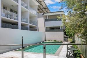 an apartment with a swimming pool in front of a building at 'Attiva' A Brisbane Gem with Pool and Private Patio in Brisbane