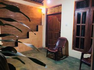 Sigiri Sunanda Home Stay في سيجيريا: غرفة بها كرسيين وباب