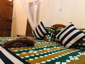 Sigiri Sunanda Home Stay في سيجيريا: دمية دب ملقاة على سرير مع الوسائد