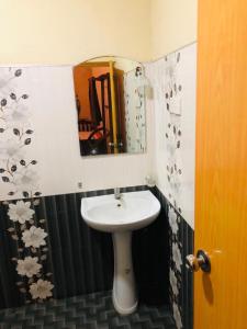 Sigiri Sunanda Home Stay في سيجيريا: حمام مع حوض ومرآة