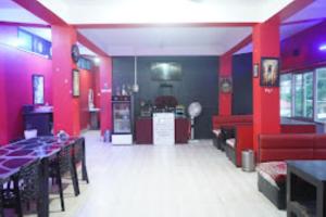 un restaurante con paredes rojas y azules, mesas y sillas en Hotel 7 Eleven Dirang en Dirāng