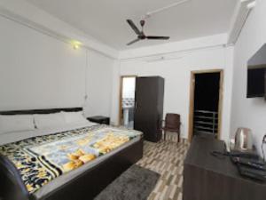 a bedroom with a bed and a ceiling fan at Hotel 7 Eleven Dirang in Dirang Dzong