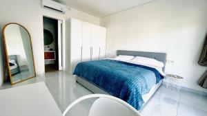 a white bedroom with a bed and a mirror at White Villa 212 in Canggu +17 photos