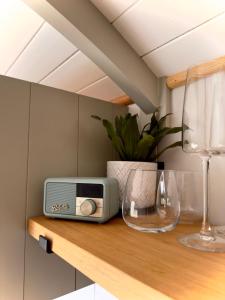 una radio sentada en una estantería de madera con una copa de vino en Private and peaceful stay in a Luxury Shepherds Hut near Truro en Truro