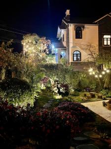 une maison avec des lumières dans un jardin la nuit dans l'établissement Villa 16 Nguyễn Viết Xuân, à Đà Lạt