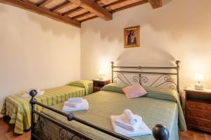 een slaapkamer met 2 bedden en handdoeken bij Agriturismo Fadanelli La Colombaia in Lamporecchio