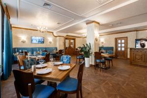 ein Speisesaal mit Tisch und Stühlen in einem Restaurant in der Unterkunft GANZ Hotel & Spa in Iwano-Frankiwsk